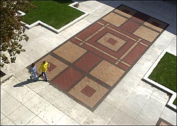 Two people walking acrose the plaza