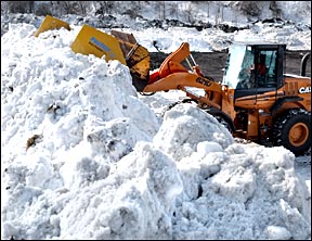 loader working on a big pile of snow