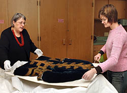 Assistant professor of textiles and clothing
Susan Torntore (left) and graduate student Jane Bute lift from its box a
properly preserved men's coat dating from the first half of the 18th
century.