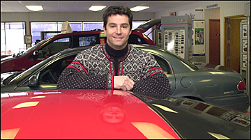 Tom DeCarlo standing by a car