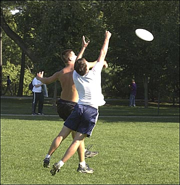 Two ISU students playing frisbee