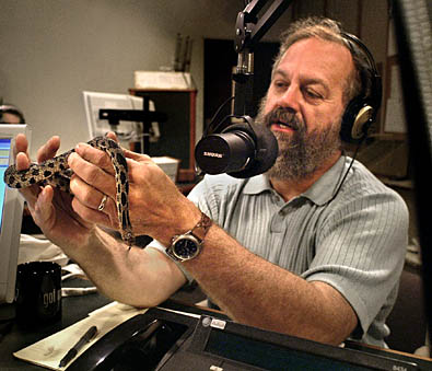 Jim Pease holding a snake while on air