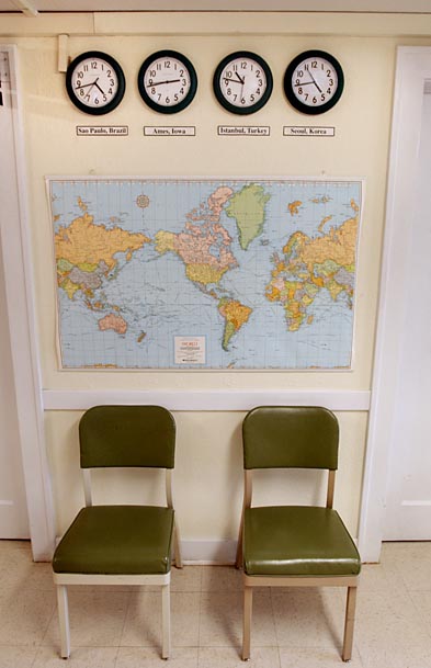 A wall
with four clocks (Brazil, Ames, Turkey, South Korea), a map and two chairs