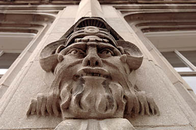 Guardian with ram horns, beard along a column of a
building