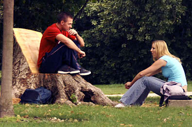 Student sitting on tree stump