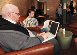 Tom Kula (foreground), a systems support
specialist with IT Services, works 'securely' on a laptop computer in
Lagomarcino Hall's Courtyard Cafe, one of dozens of interior areas on campus
with access to wireless