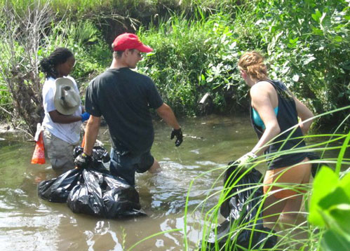 Three volunteers wading along
the creek, nabbing trash.